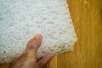 POV male hand holding new Polyethylene plastic mattress made from recycled plastic