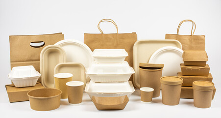 Group shot of biodegradable and recyclable food packaging on white background, paper plates, containers, bags