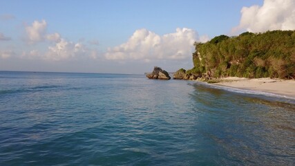 Big stone horizon beach sunset late afternoon heat Indonesia Bali ocean sea waves landscape drone view Indonesia travel nature vacation walk in exotic places sand cliff vegetation tropical