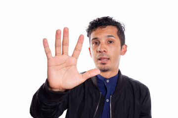 Fototapeta premium Young adult indicating to stop with hand. White background. Please stop.