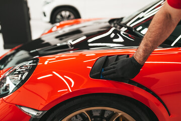 A man cleaning car, car detailing (or valeting) concept. Selective focus.