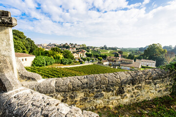 View of Saint-Emilion medieval village, vineyards, ancient stone wall on a summer day,  World Heritage by UNESCO