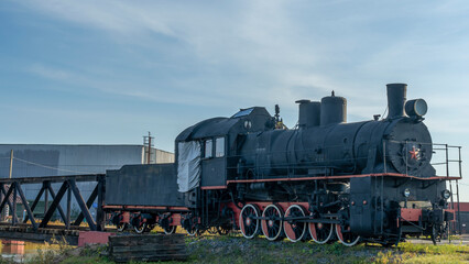 Fototapeta na wymiar Retro Soviet steam locomotive. Veteran railways. Vintage black steam locomotive train rush railway.