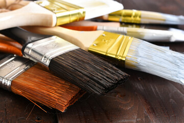 An image of several old used paint brushes covered in dried paint and stain. 
