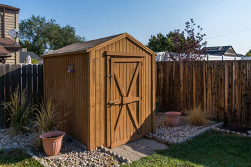 A backyard tool shed with a wooden fence. - Powered by Adobe