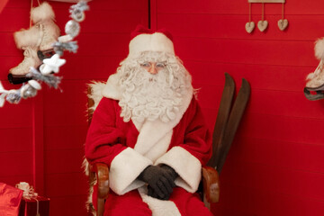 Santa claus is sitting in a chair in his house