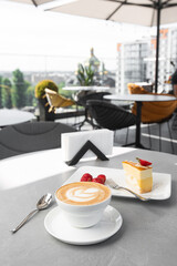 Classic cheesecake with fresh strawberry with cup of coffee on white table. Close Up view. Tasty breakfast. Piece of cake on plate, white cup on white marble background.