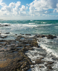 landscape of stormy Mediterranean sea with blue sky and white clouds and white sea foam off the coast of Turkey, Avsalar, Alanya during a storm in autumn