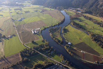 Fototapeta premium Aerial View of green Farm Field in Fraser Valley. Located in Dewdney near Chilliwack, British Columbia, Canada.