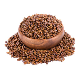 Cassia tora beans in wooden bowl, isolated on white background. Sicklepod or Senna obtusifolia. Clipping path.