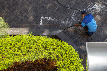 worker with high pressure water cleaner cleans a stone surface in Brazil