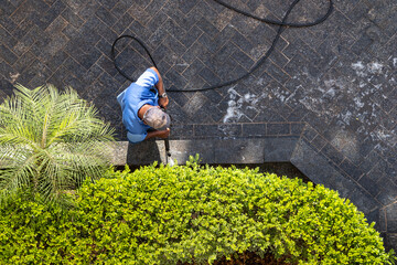 worker with high pressure water cleaner cleans a stone surface in Brazil