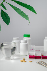 Jars of pills and water. Pill box with pills for morning and evening. Open pill box with pills or vitamins for senior patient