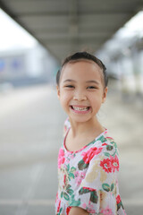 Happy Little asian girl child showing front teeth with big smile and laughing