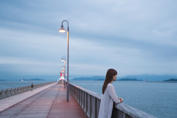 夕暮れの海岸にいる女性