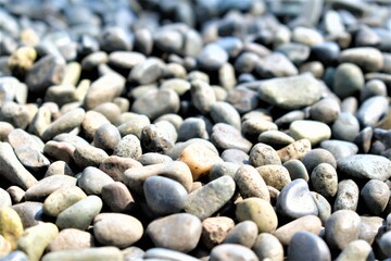 Smooth round pebbles stone abstract texture and background. Gray dry pebble sea shore beach close-up. High quality photo