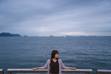 夕暮れの海岸にいる女性