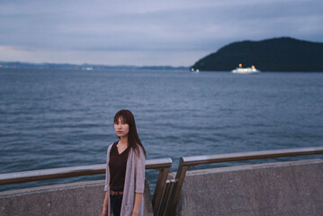 Fototapeta premium 夕暮れの海岸にいる女性