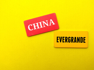 Colored wooden board written with text CHINA EVERGRANDE on a yellow background. Business concept.