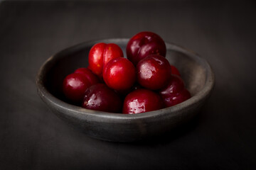 plate of fresh plums on dark background