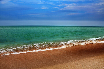 Blue sea wave on a pebble beach.