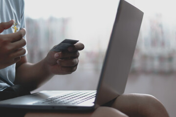 Close up man purchusing or paying domestic bills online by credit card, using laptop, young man customer making secure internet payment.