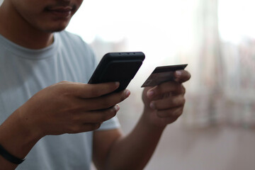 Close up man purchusing or paying domestic bills online by credit card, using laptop, young man customer making secure internet payment.