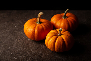 Small orange pumpkins with black background. Pumpkins are widely grown for commercial use and as food, aesthetics, and recreational purposes. Much consumed on Thanksgiving Day and Halloween decoration