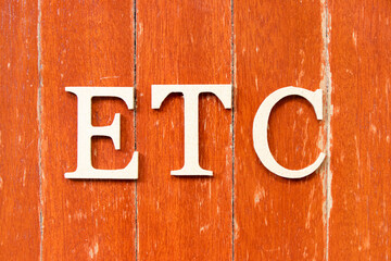 Alphabet letter in word etc (abbreviation of et cetera) on old red color wood plate background