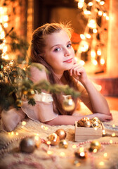 cute girl in a Christmas mood with Christmas balls and fir branches. Christmas home concept