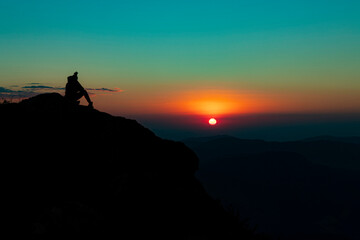 A person admiring the Sunset over the Mountain