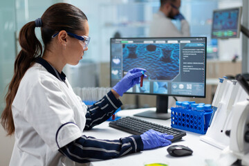 Specialist biologist researcher holding blood medical test tubes analyzing virus diagnostic...