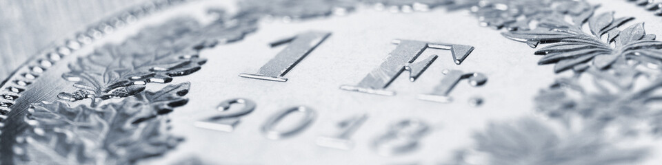 1 Swiss franc coin close-up. Banner on the topic of the economy, business, money of Switzerland. Light pale gray headline. Banking and the national currency. Macro