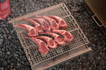 Lamb chop being grilled under flames At outdoor