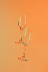 two glasses of champagne with neon orange lights. modern futurism 2022 year background. minimalism. surrealism. creative decoration idea
