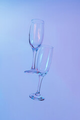two glasses of champagne with neon blue lights. modern futurism 2022 year background. minimalism. surrealism. creative decoration idea