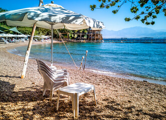 Sandy beach with chairs and umbrellas at the Red Sea in Eilat - famous tourist resort and recreational city in Israel

