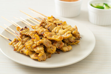 Pork satay with peanut sauce pickles which are cucumber slices and onions in vinegar