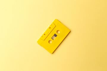 Vintage yellow audio cassette on bright yellow background. Audio cassettes with magnetic tape....
