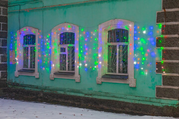 on the windows of the building green hung Christmas garlands. These are decorations for the new year, Christmas