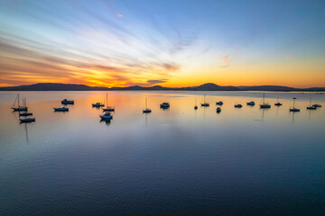 Aerial sunrise waterscape with boats and high cloud