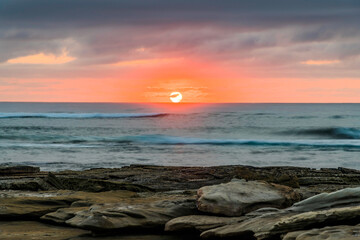 Sunrise seascape with rocky foreground