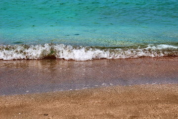 Blue sea wave on a pebble beach.
