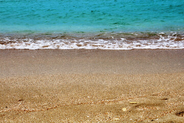 Blue sea wave on a pebble beach.