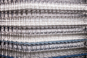 Glass factory, industrial production of glass containers. Modern technology, robots machines make products.Party bottles for drinks. Technological work at the plant. Working atmosphere with copy space