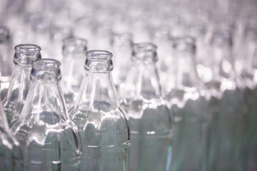 Glass factory, industrial production of glass containers. Modern technology, robots machines make products.Party bottles for drinks. Technological work at the plant. Working atmosphere with copy space