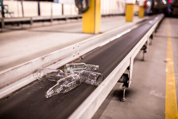 Glass factory, industrial production of glass containers. Modern technology, robots machines make products.Party bottles for drinks. Technological work at the plant. Working atmosphere with copy space