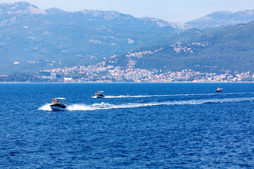 Obraz premium Boat tour on the water bay . Speeding boats on the Kotor Bay in Herceg Novi Montenegro 