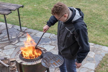 a man with glasses watches the fire