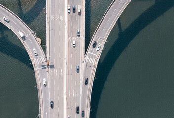 Road junction and bridge on river in the city, aerial view.